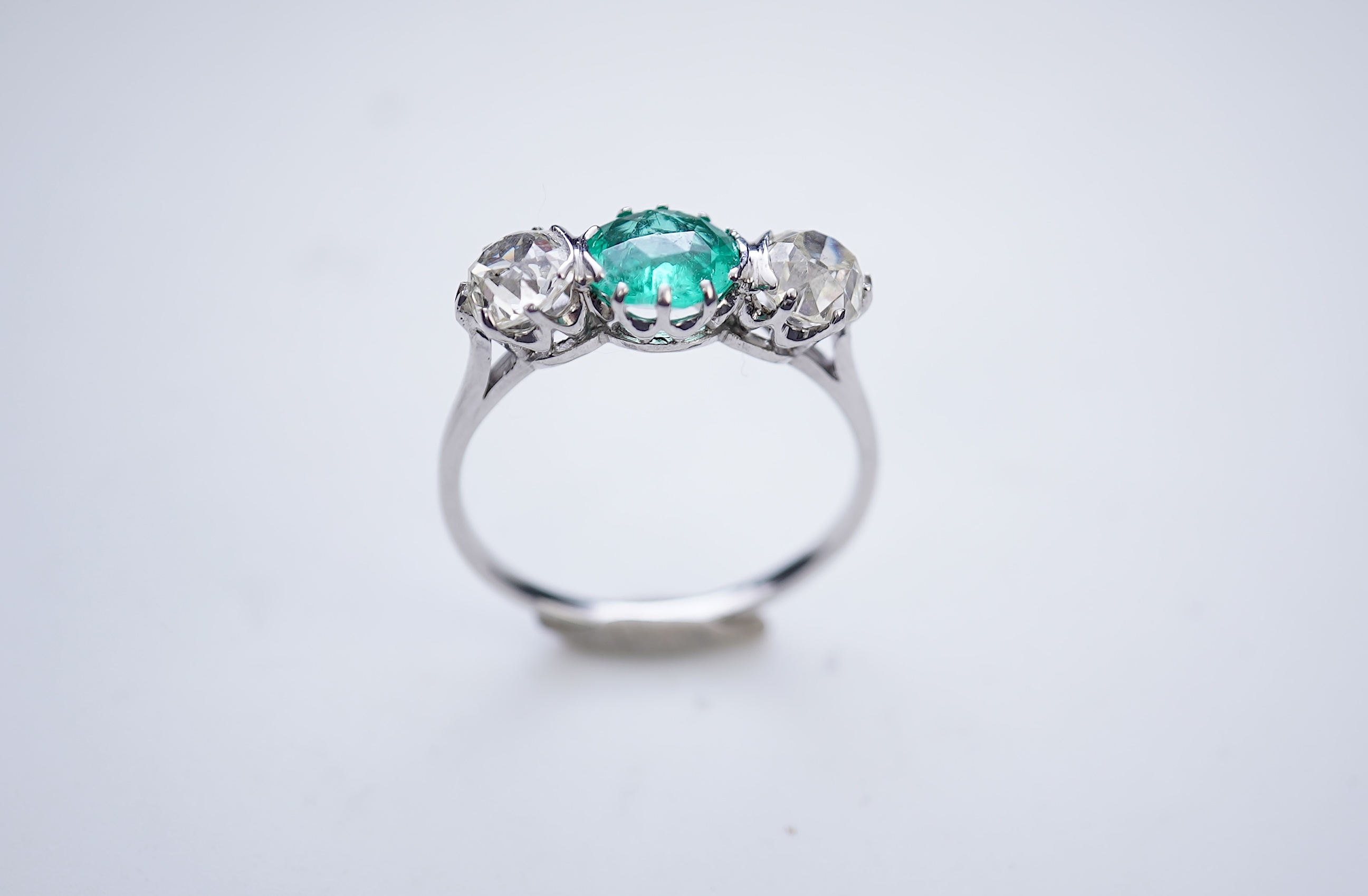 An attractive emerald and diamond three-stone ring, early 20th century